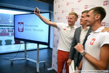 Minister Witold Bańka z beneficjentami team100 - Aleksandrem Kossakowskim oraz przewodnikiem Krzysztofem Wasilewskim