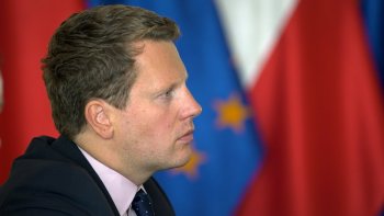 Ambasador Estonii Martin Roger na tle flag